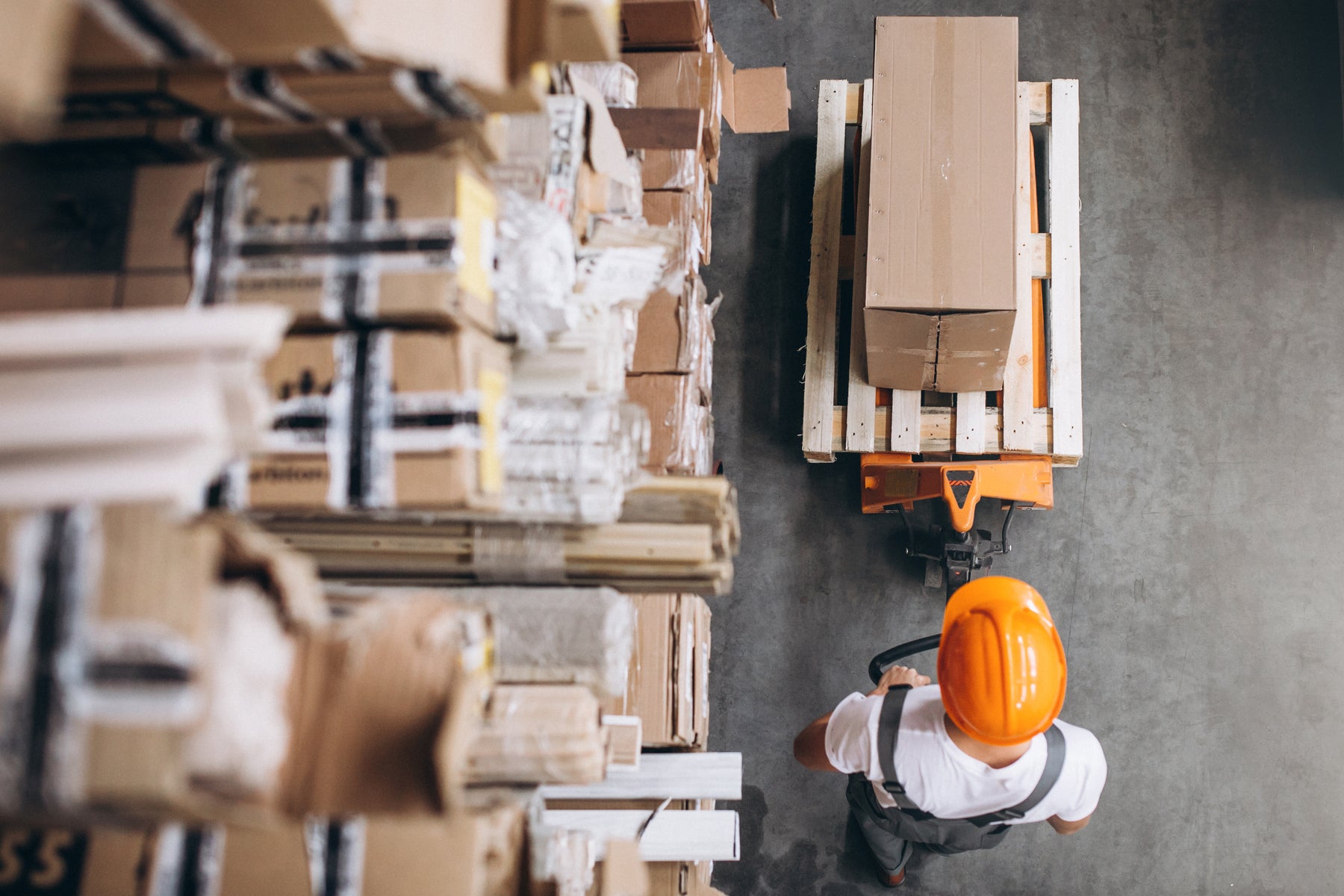 Medewerker vervoert dozen met een palletwagen in het fulfilmentmagazijn van Pick & Pack.